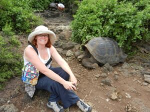 Sally Brannan Hurt ’92 with a giant tortoise in the Galápagos Islands on a Mary Washington Alumni on the Road trip. The experience led her to establish the Sally Brannan Hurt '92 Study Abroad Scholarship in Biology to support students go on faculty-led trips to the islands. Photo courtesy of Sally Brannan Hurt. 