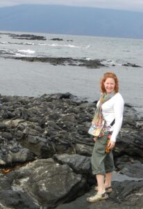 Sally poses with dozens of marine iguanas camouflaged into the rocks, one of the many species found on the biodiverse Galápagos Islands. Photo courtesy of Sally Brannan Hurt.