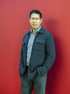 Jin Wong '97 poses for a picture in the College of Business. A business administration major at Mary Washington, he recently accepted the position of assistant general manager for baseball administration with the Chicago White Sox, after 24 years with the Kansas City Royals. Photo by Tom Rothenberg.
