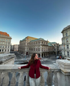 Sofia studied abroad in Vienna, Austria, in spring 2023. Here, she poses for a photo on the balcony of the Albertina Museum, overlooking the Wiener Staatsoper (Vienna State Opera). Photo courtesy of Sofia Taylor.