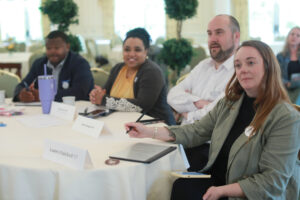 From left: Alumni Board members Harry Thomas '97, Lisa Maloney Keyser '05, and Brian Reagan '04 and Young Alumni Council Chair Lauren Rainford '15 listen to the presentations. Photo by Karen Pearlman.