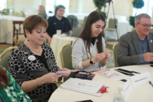 From left: Alumni Board President Vicki Sprague Ravenel '77, member Katherine Redmiles '15, and President-Elect James Llewellyn '87, examine sensory toys handed out by Assistant Dean of Students Chris Porter before her presentation. These toys help calm students with autism spectrum disorder, Porter said. Photo by Karen Pearlman.