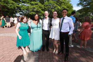 Students pose with President Paino in the Jepson Alumni Executive Center courtyard. Photo by Karen Pearlman.