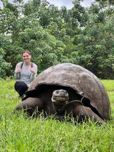 Madeline received the Sally Brannan Hurt '92 Study Abroad Scholarship in Biology, which gave her the opportunity to travel to the Galápagos Islands to study the flora and fauna of one of the most biodiverse places on the planet. Here, she poses for a photo with a Galápagos tortoise at an ecological reserve, El Chato Ranch, on the island of Isabela. Photo courtesy of Madeline Brunt.