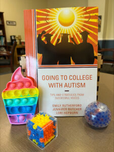 The Impact Grant for 'Soft Landings' covered the cost of a textbook, 'Going to College with Autism,' seen here with a collection of fidget toys to help students when they feel overstimulated. The book is filled with success stories of students with autism spectrum disorder. Photo courtesy of CJ Porter.