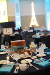 Suitcases, globes, and postcards decorated the tables while the Eiffel Tower and a Japanese temple illuminated the walls of Chandler Ballroom. Photo by Karen Pearlman.