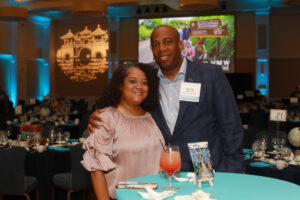 Lisa Patillo Miller ’96 and the Hon. Kerwin Miller Sr. '95 enjoy the cocktail hour at the 2024 Celebration of Giving, while a Center for International Education student slideshow plays in the background. Photo by Karen Pearlman.