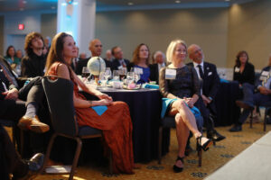 President Troy Paino and wife Kelly (right), who were the evening's hosts, and other guests listen to UMW student speakers talk about their international education experiences at Mary Washington. Photo by Karen Pearlman.