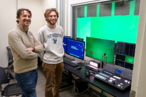 Digital Knowledge Center Director Cartland Berge (left) and UMW senior Steve McClanahan pose for a picture in the Charnoff Production Studio, along with the upgraded technology that was supported by Fund for Mary Washington Impact Grant. A gift from Mikhael Charnoff '95 and Katherine Valentine Charnoff '04 covered the cost of an accessible production desk to house the new broadcast panel. Photo by Sam Cahill.