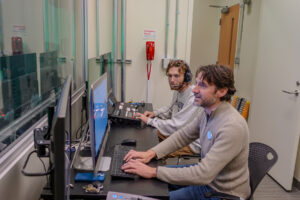 Mikhael Charnoff '95 and wife Katherine Valentine Charnoff '04 contributed a gift that helped pay for a production desk that increases accessibility. Cartland (foreground) and Steve test out the broadcast panel, which is housed in the production desk. Photo by Sam Cahill.