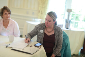 Alumni Board member Colette Strawn Johnson '97 (right) takes notes during the Fund for Mary Washington Impact Grant presentations while Alumni Board member Jennifer Boyd Ross '79 looks on. Photo by Karen Pearlman.