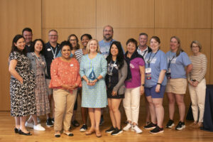 JB Blair ’82 (center) poses with past and present members of the Alumni Association Board of Directors, as well as Executive Director of Alumni Engagement and Advancement Communications Mark Thaden ’02 (far left, back) and her former colleague, UMW Dean of Admissions and Associate Vice President Melissa Yakabouski ’94 (far left, front), and Barbara Dixon ’82 (far right). Photo by Karen Pearlman.