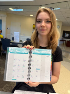 First-year student Crow Sindelar shows off their new day planner provided by the LaunchPad program. Supported by a Fund for Mary Washington Impact Grant, the four-week program gives incoming students a crash course in syllabus organization, time management, campus involvement, and how to utilize computer tools like Canvas and Microsoft Office.