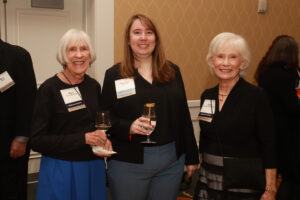 Three alumnae from the classes of 1967, 2011, and 1969 pose for a photo with wine glasses.