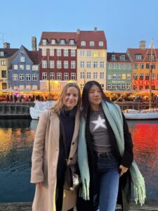 Description: Two college students visiting Nyhavn, a historic 17th-century harbor in Copenhagen, Denmark. Caption: Carly and a friend she met through the MICEFA program visited Nyhavn, a historic 17th-century harbor in Copenhagen, Denmark. MICEFA (Mission Interuniversitaire de Coordination des Echanges Franco-Américains) is a nonprofit that brings together 18 French universities with over 65 partners in North America. Photo courtesy of Carly Radgowski. Photo courtesy of Carly Radgowski.