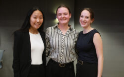 Three smiling students in professional dress.