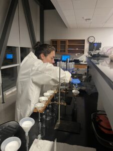 Student wearing a white lab coat working in a UMW Jepson Science Center lab.