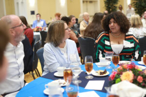 A couple chatting with their scholarship recipient.