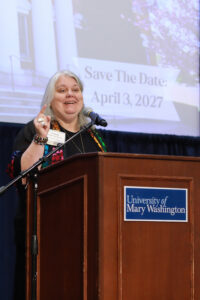 A donor speaker standing at a podium with a University of Mary Washington sign on it.