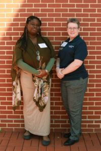 A student and donor standing in front of a brick wall.