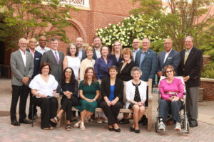 The members of the UMW Foundation Board of Trustees outside dressed in nice clothing on a sunny day.