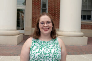 Student smiling in front of Virginia Hall. 