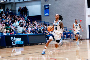 A UMW Men's Basketball player during a game.