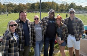 Group photo of six people at Homecoming all wearing matching plaid shirts.