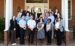 A group of UMW students, faculty, and staff standing on the Kalnen Inn steps.