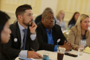Four alumni listen to presentations.