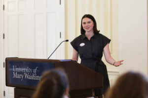A student speaks through the microphone at a podium.