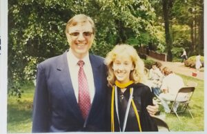 A early '90s photo of a student wearing her graduation gown and her professor.