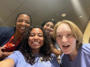 Three smiling students with UMW Dean of Students Melissa Jones, who also serves as associate vice president of student affairs.