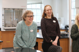 Two laughing professors standing in a laboratory.