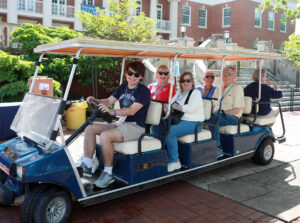 A student-led golf cart tour of campus stops in front of Lee Hall.