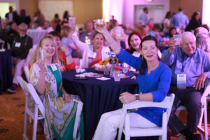 A group of alumni raise their glasses in a toast while seated a table at the all-class party during Reunion Weekend.
