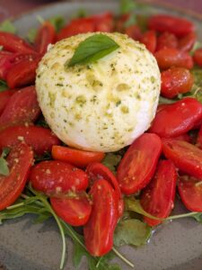 Burrata and tomato salad on top of arugula.