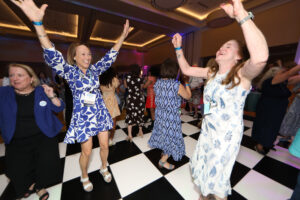 Alumni dancing on a black-and-white checkered floor during the all-class party.