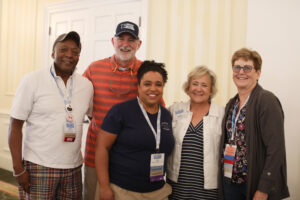 A group of five alumni from different class years at the Sunday farewell breakfast.