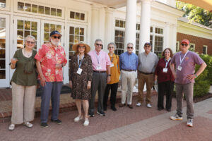 A group of retired faculty and staff pose for a photo outside the Jepson Alumni Executive Center.