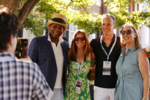 A young alum takes a cell phone picture of Associate Vice President of Student Affairs and Dean of Student Life Emeritus Cedric Rucker '81 and Vice President for Advancement and Alumni Engagement Katie Turcotte with an alumni couple at Brompton.